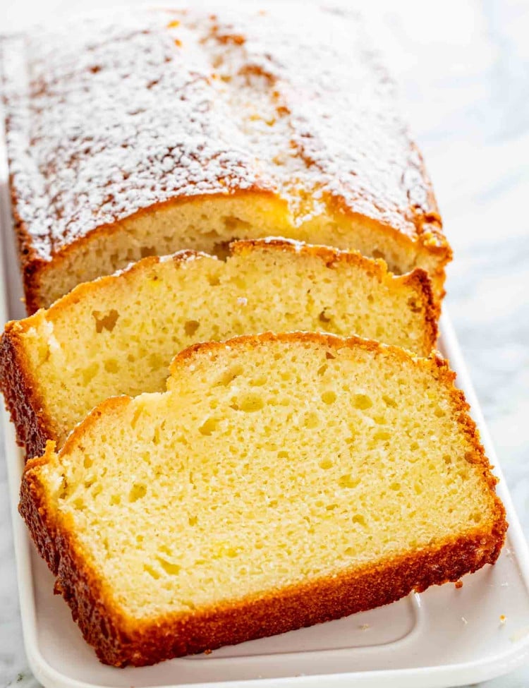 sliced up lemon yogurt cake on a white platter.