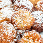 close up shot of apple fritters dusted in powdered sugar