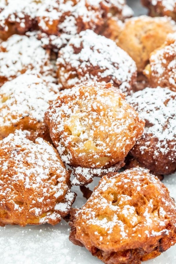 close up shot of apple fritters dusted in powdered sugar