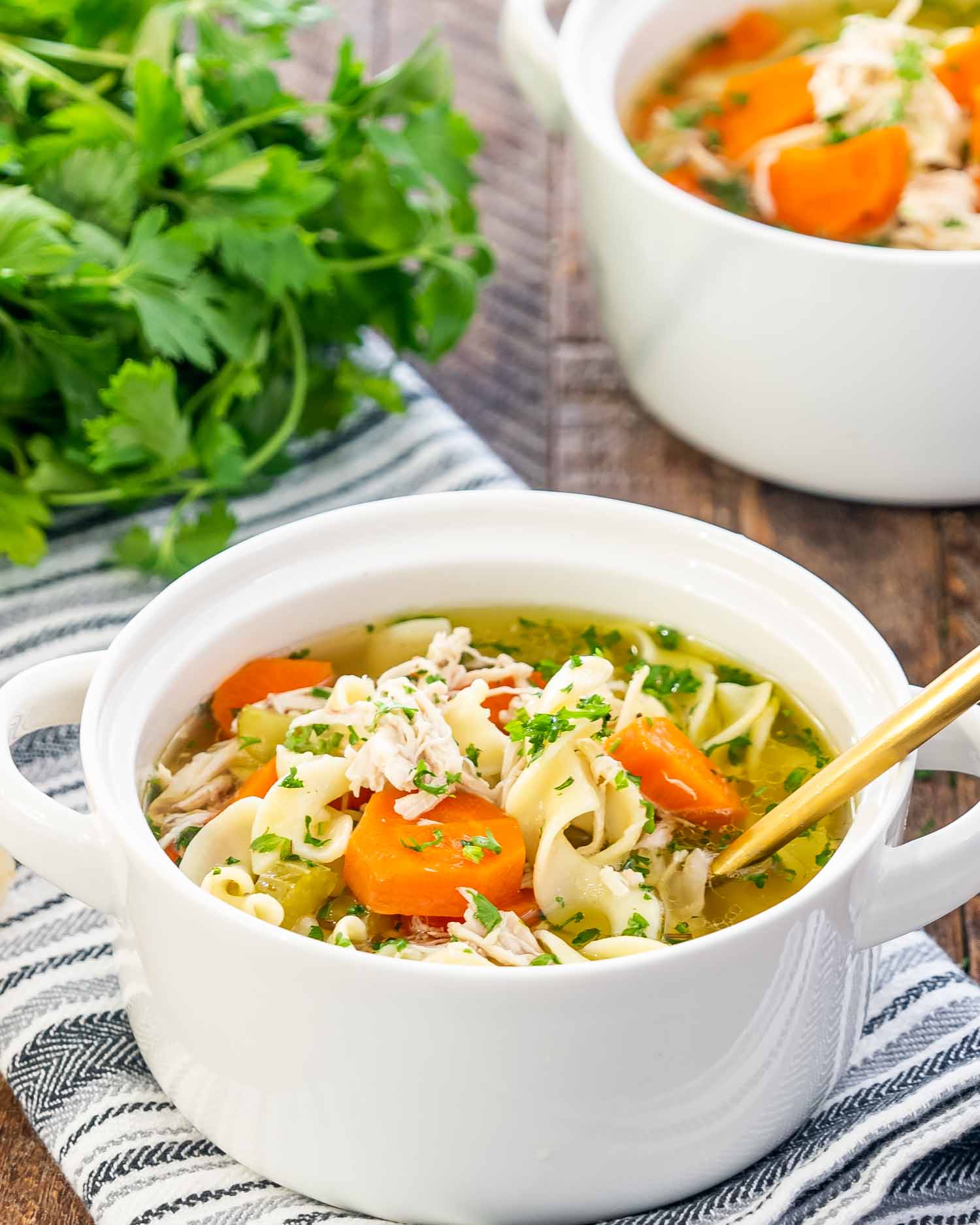 crockpot chicken noodle soup in a white bowl.