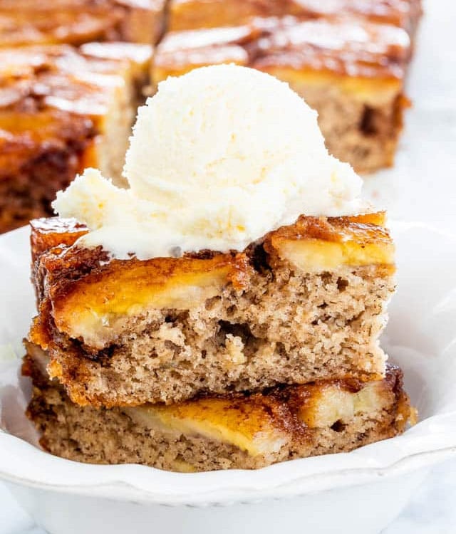 two slices of banana upside down cake topped with a scoop of vanilla ice cream in a bowl
