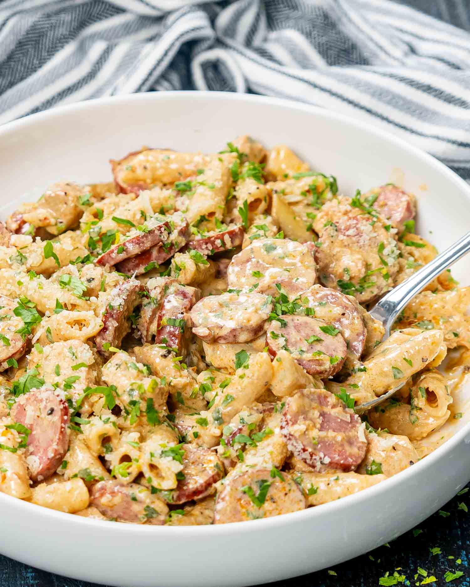 cajun chicken pasta garnished with parsley in a white bowl.