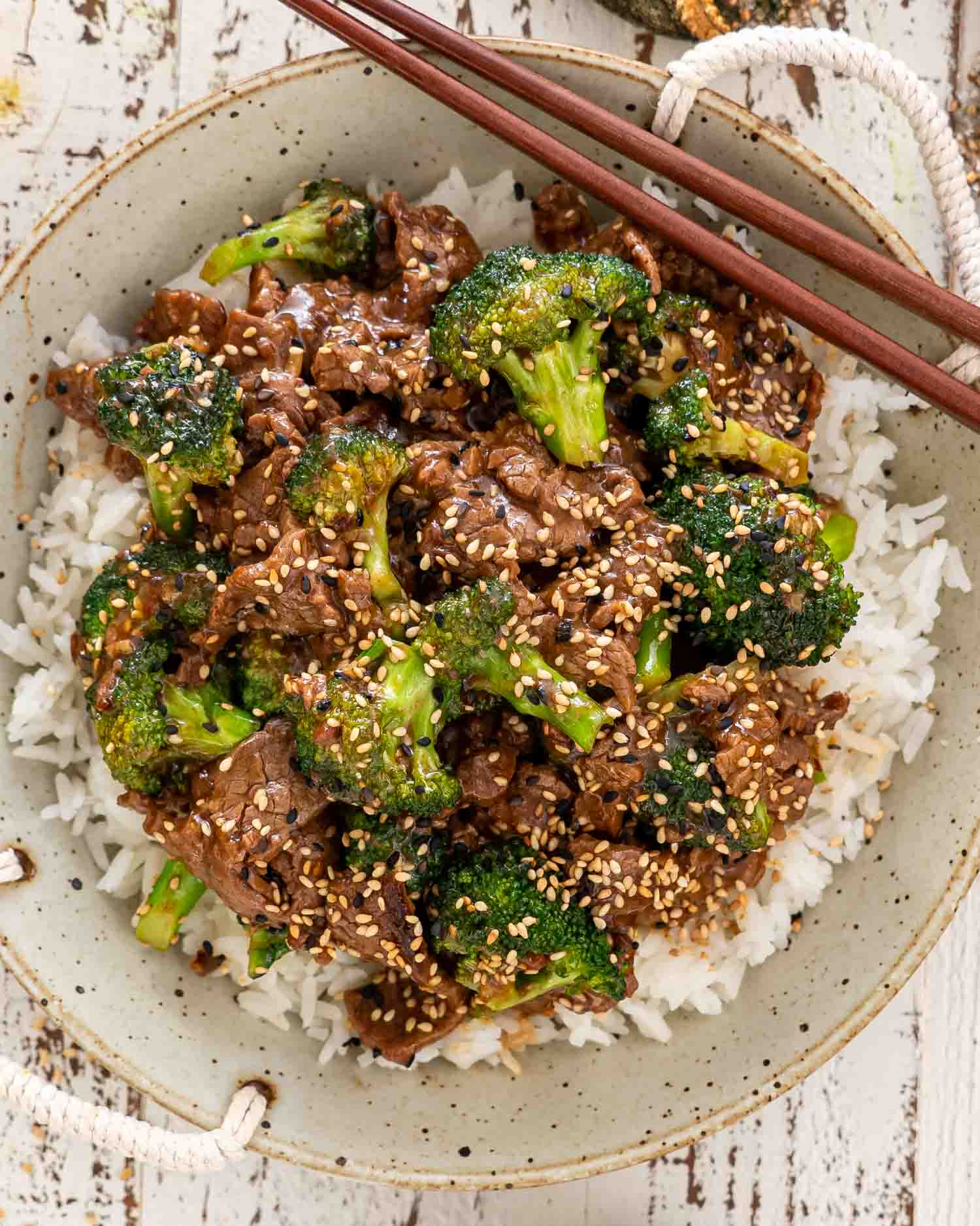 beef and broccoli that was made in an instant pot over a bed of rice in a bowl.