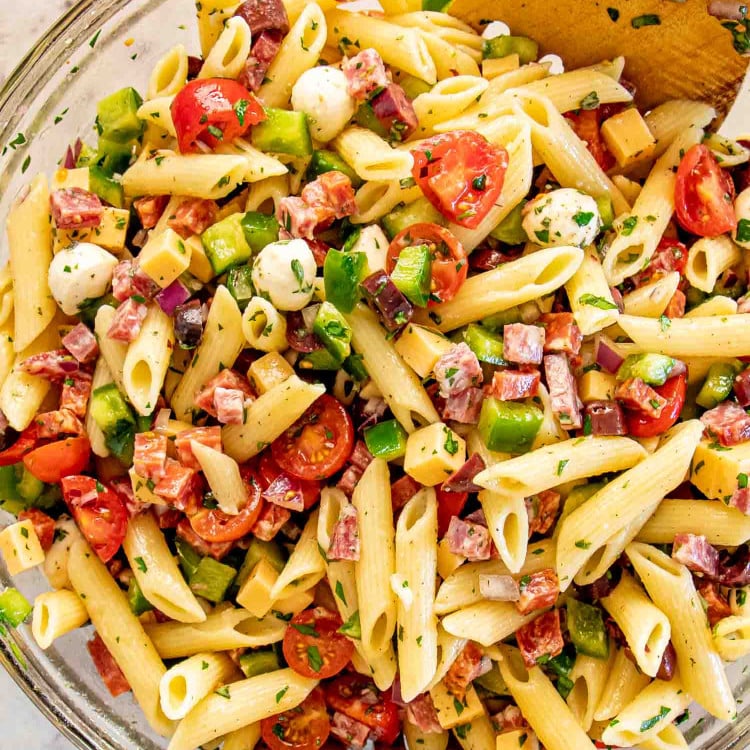 freshly made and tossed italian pasta salad in a bowl.