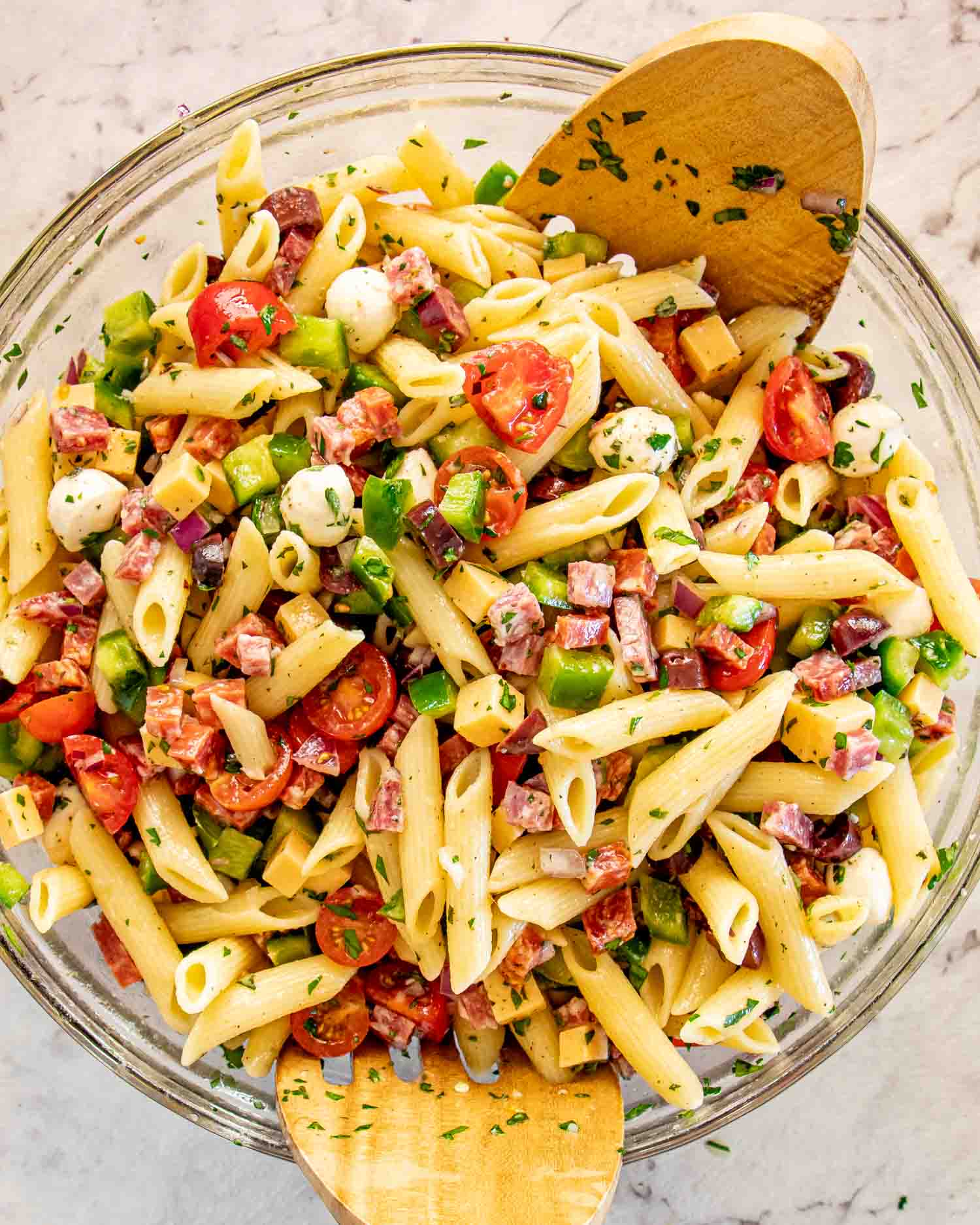 freshly made and tossed italian pasta salad in a bowl.