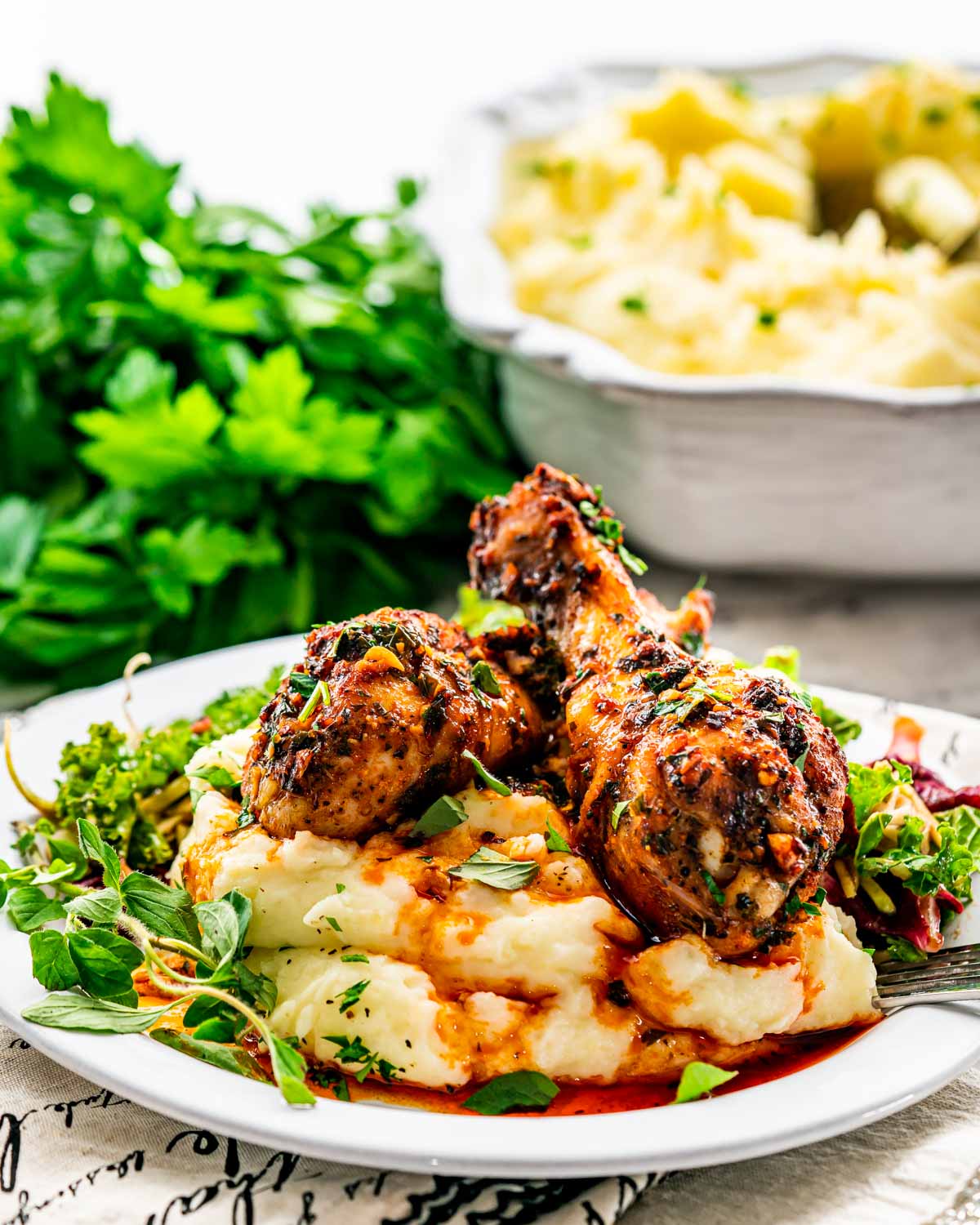 garlic paprika chicken drumsticks on a bed of mashed potatoes.