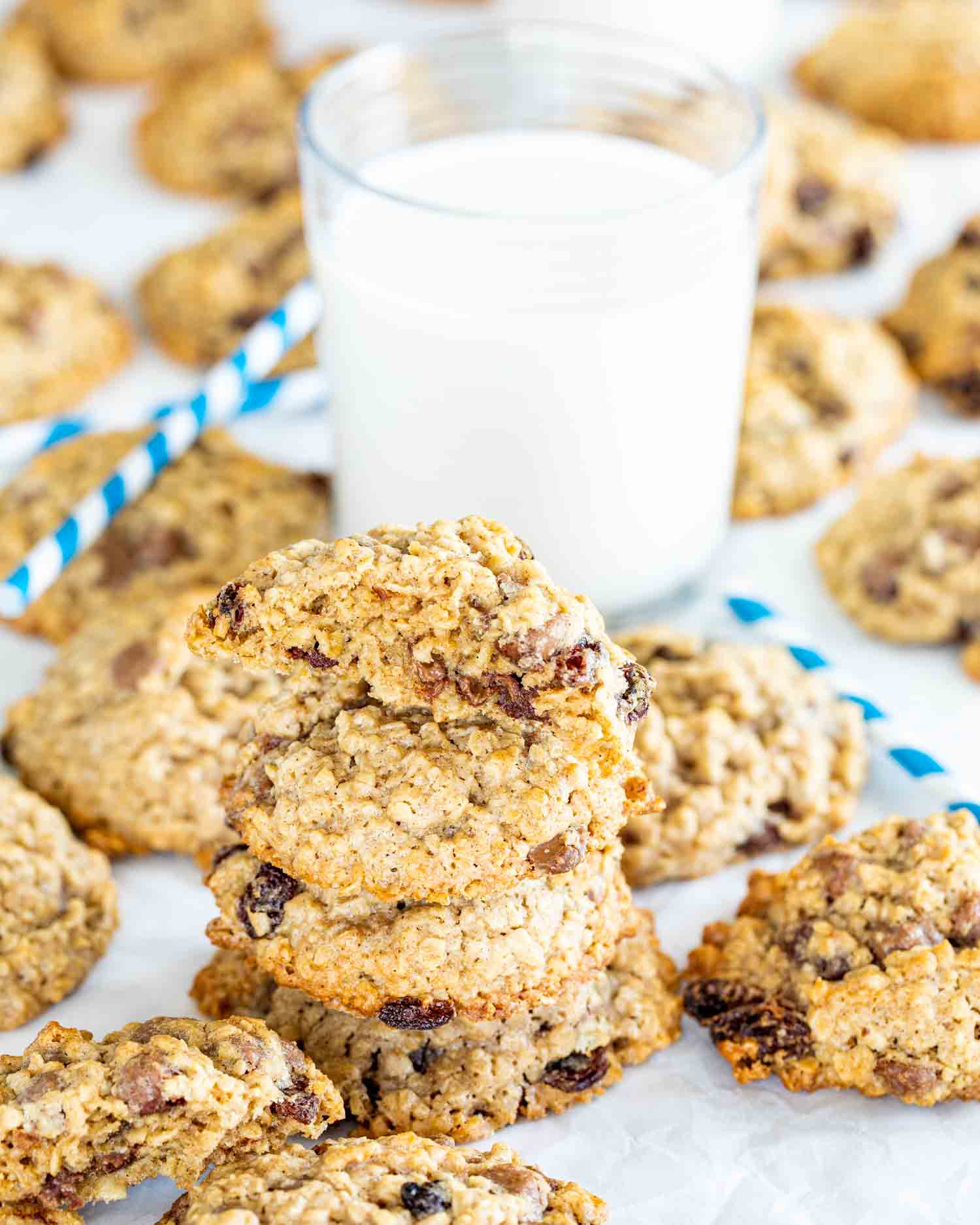 a stack of oatmeal cookies with a glass of milk.