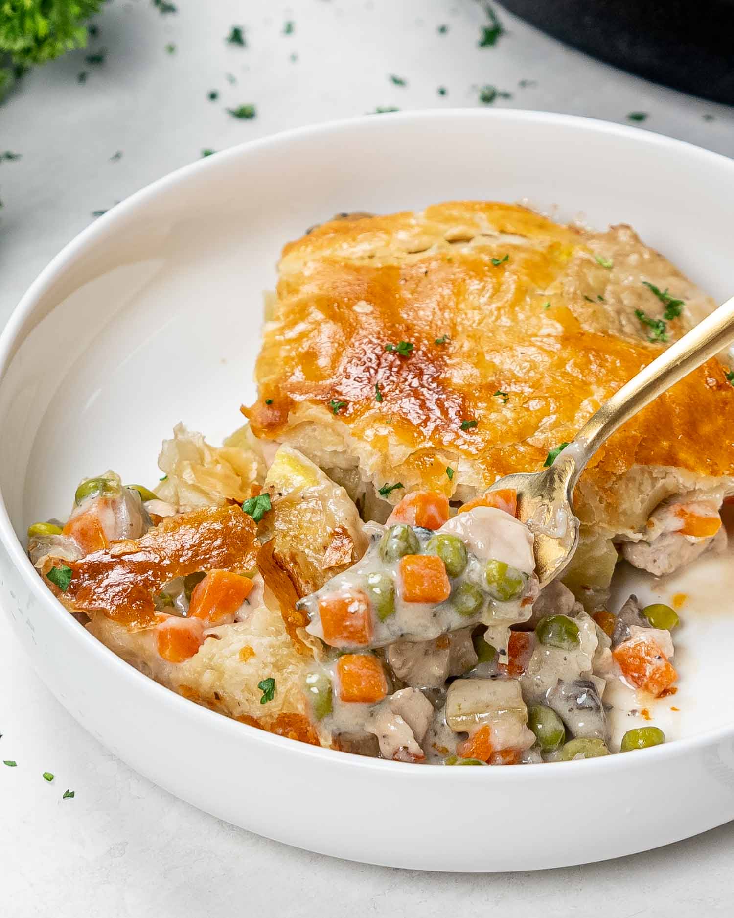 a serving of chicken pot pie in a white bowl.