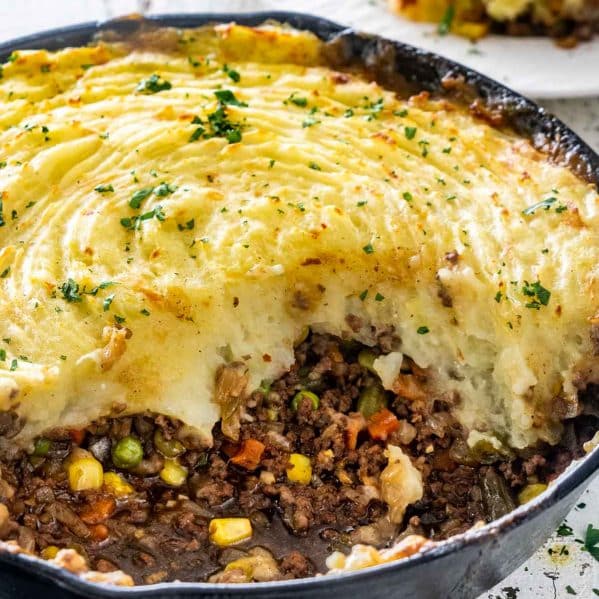 shepherd's pie in a skillet with a serving taken out of it.