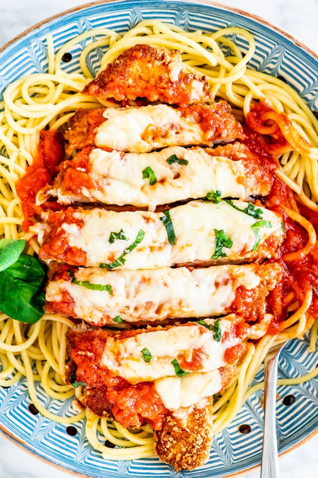 sliced Chicken Parmesan over a bed of spaghetti