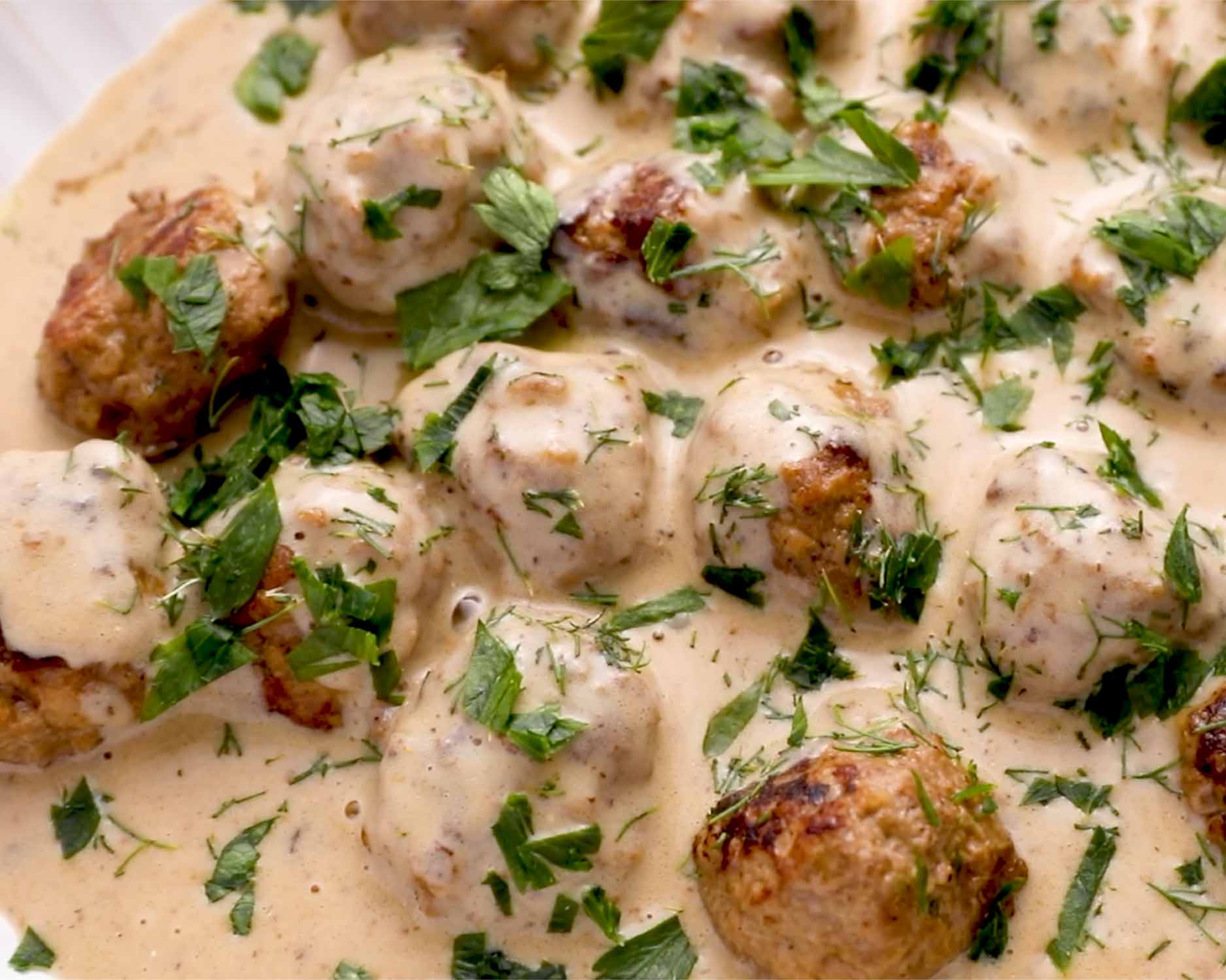 instant pot swedish meatballs in a serving platter garnished with dill and parsley.