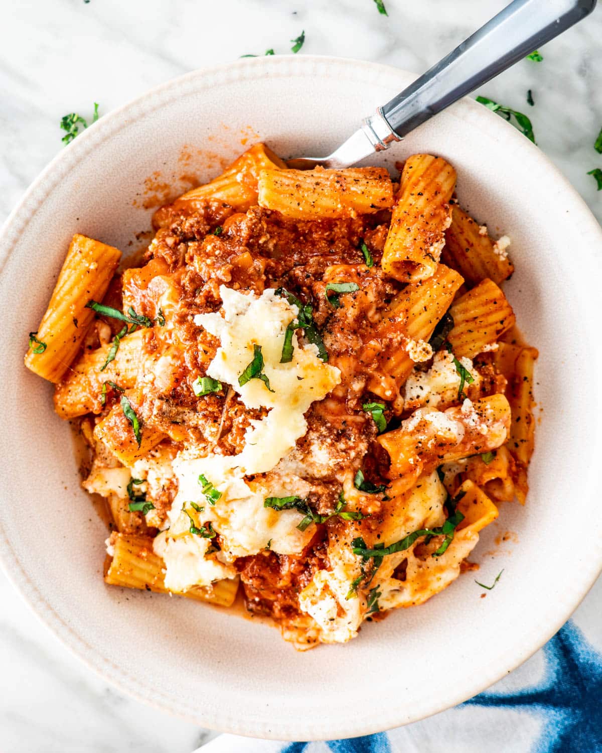 overhead shot of baked ziti in a white bowl