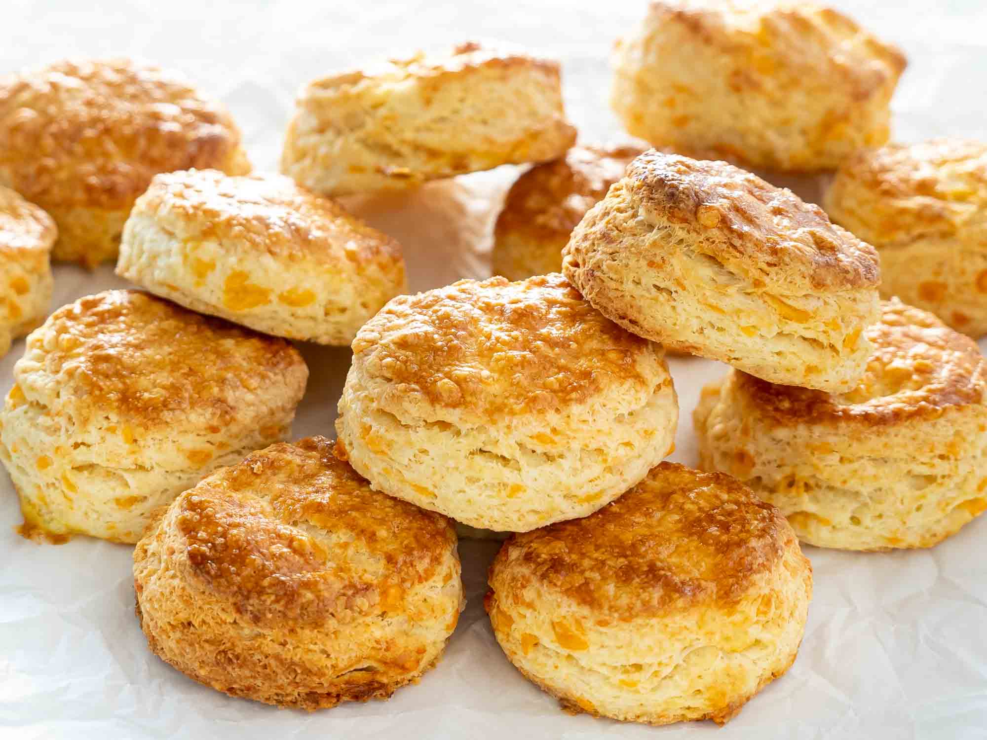 a few freshly baked cheese biscuits on a piece of parchment paper.