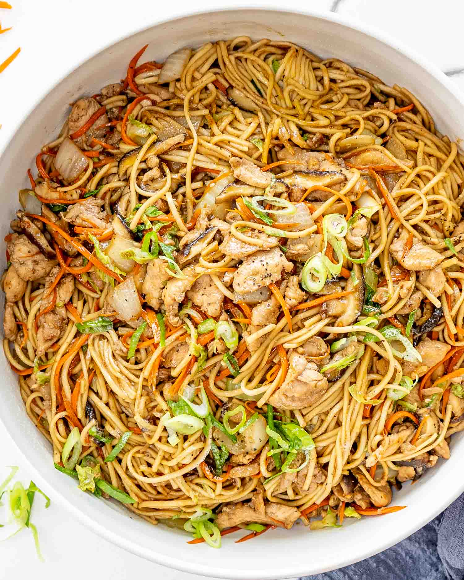 freshly made chicken lo mein in a big white bowl.