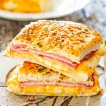 a ham and cheese pocket sliced in half on a plate.