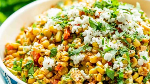 mexican street corn salad in a bowl garnished with cilantro and cotija cheese.