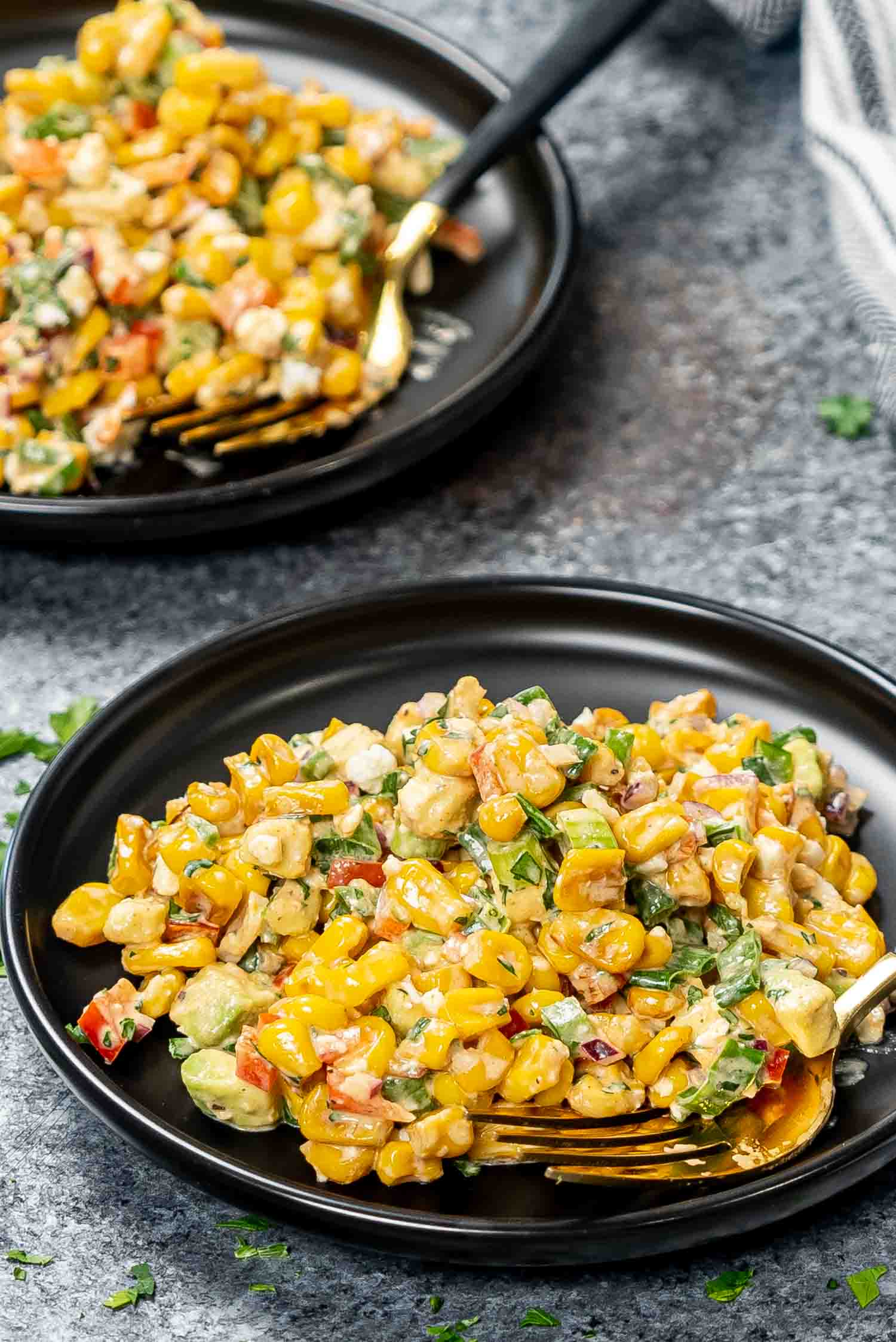 a serving of mexican street corn salad on a blackplate.
