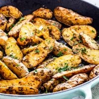 side view shot of roasted potato fingerlings in a skillet