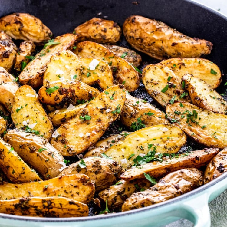 side view shot of roasted potato fingerlings in a skillet