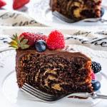 side view shot of a slice of zebra cake on a plate with a fork