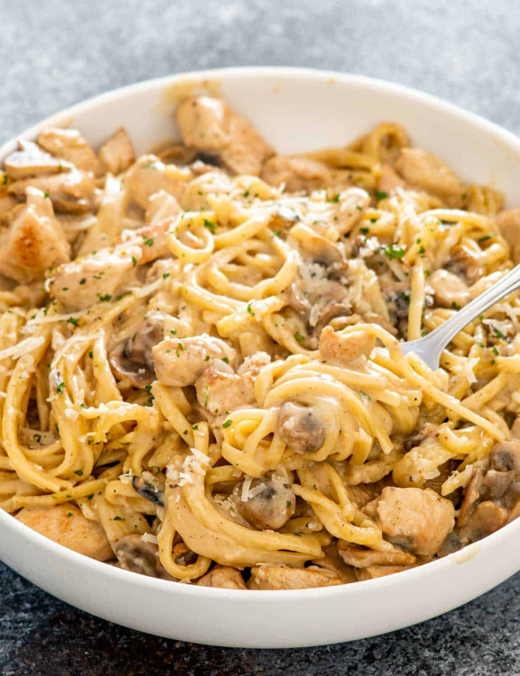 chicken tetrazzini garnished with parmesan cheese in a white bowl.