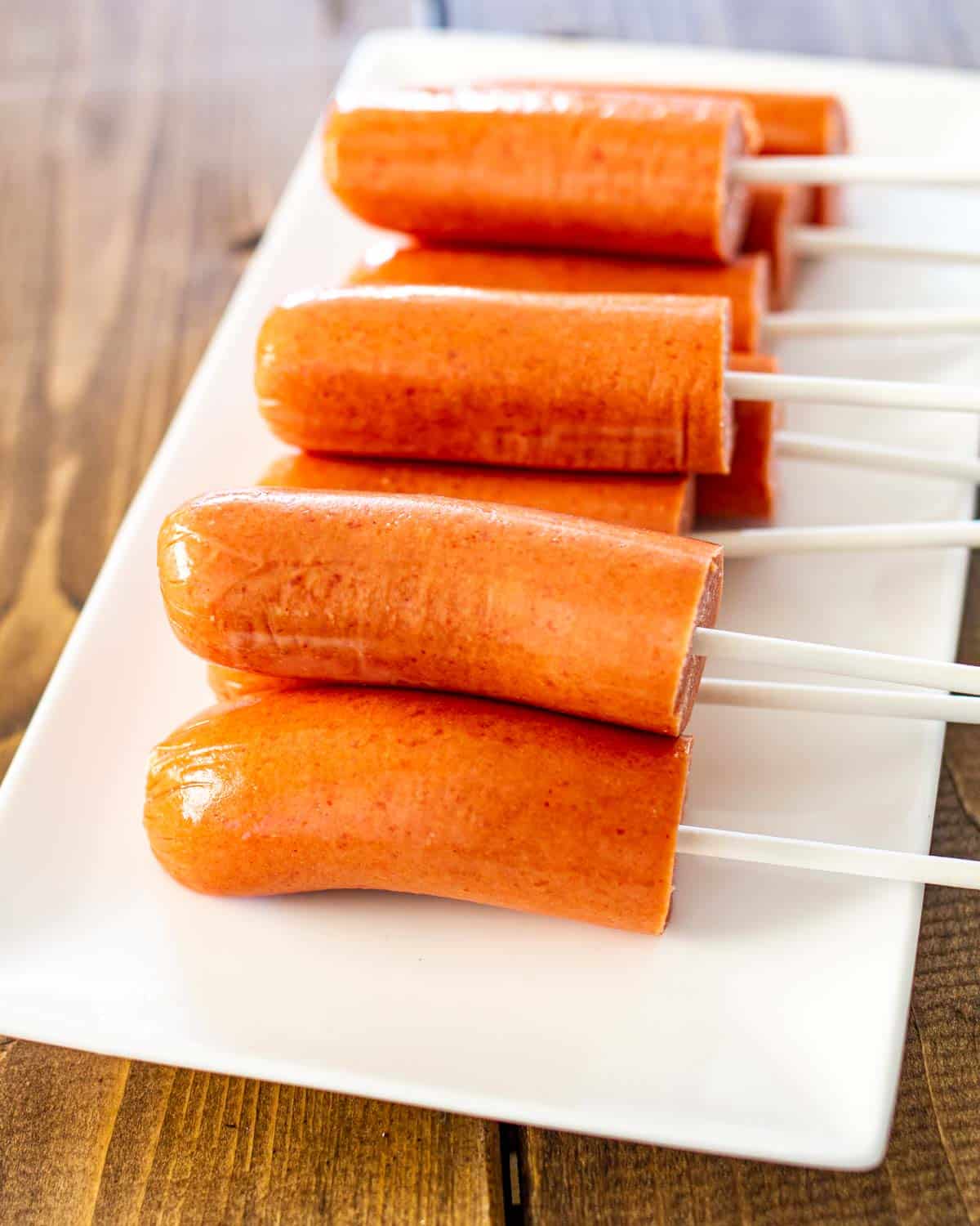 hot dogs cut in half with a lollipop stick in them.