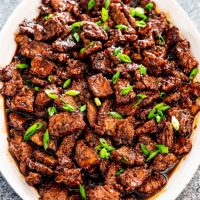 mongolian beef on a white serving platter.