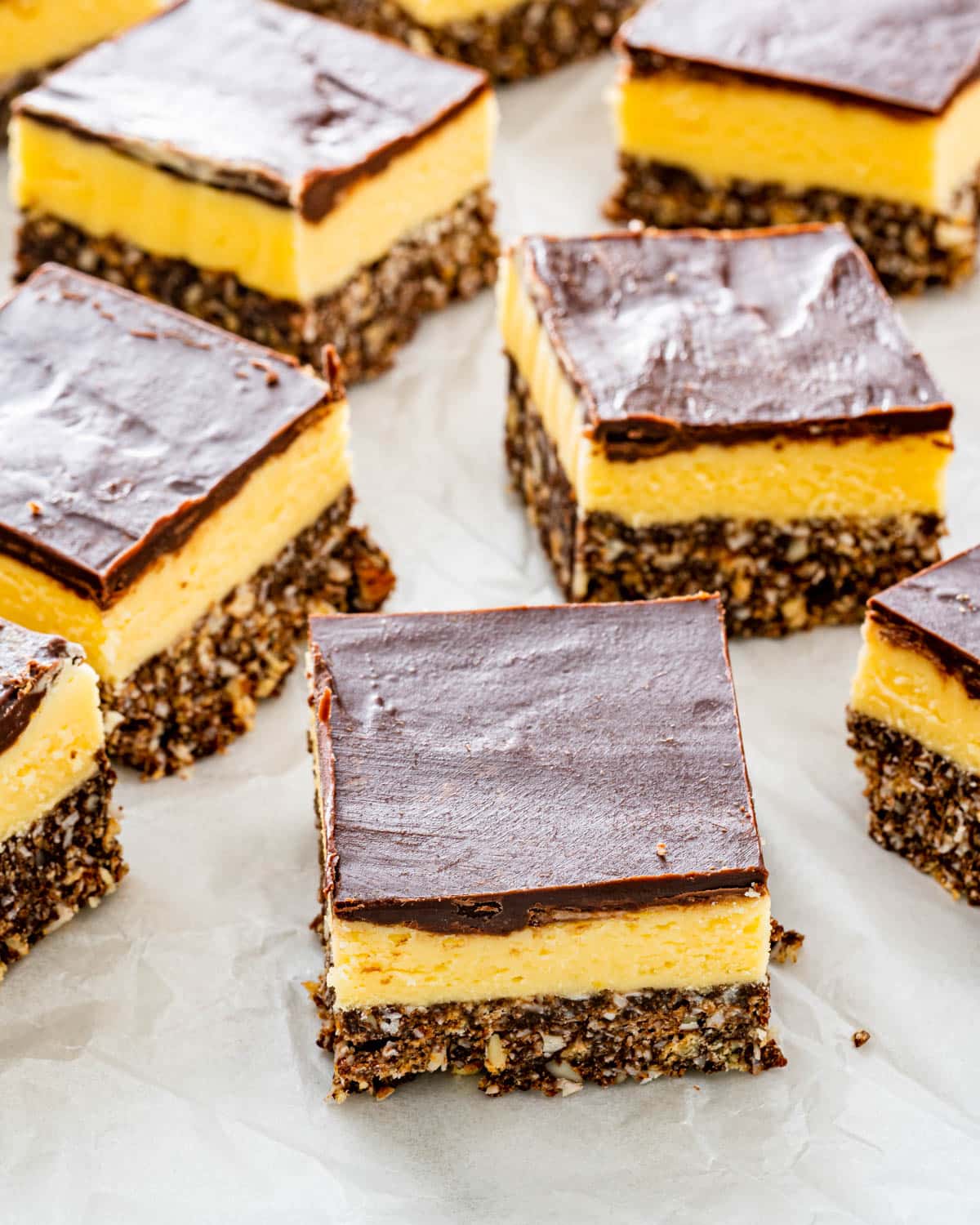 a bunch of nanaimo bars on parchment paper