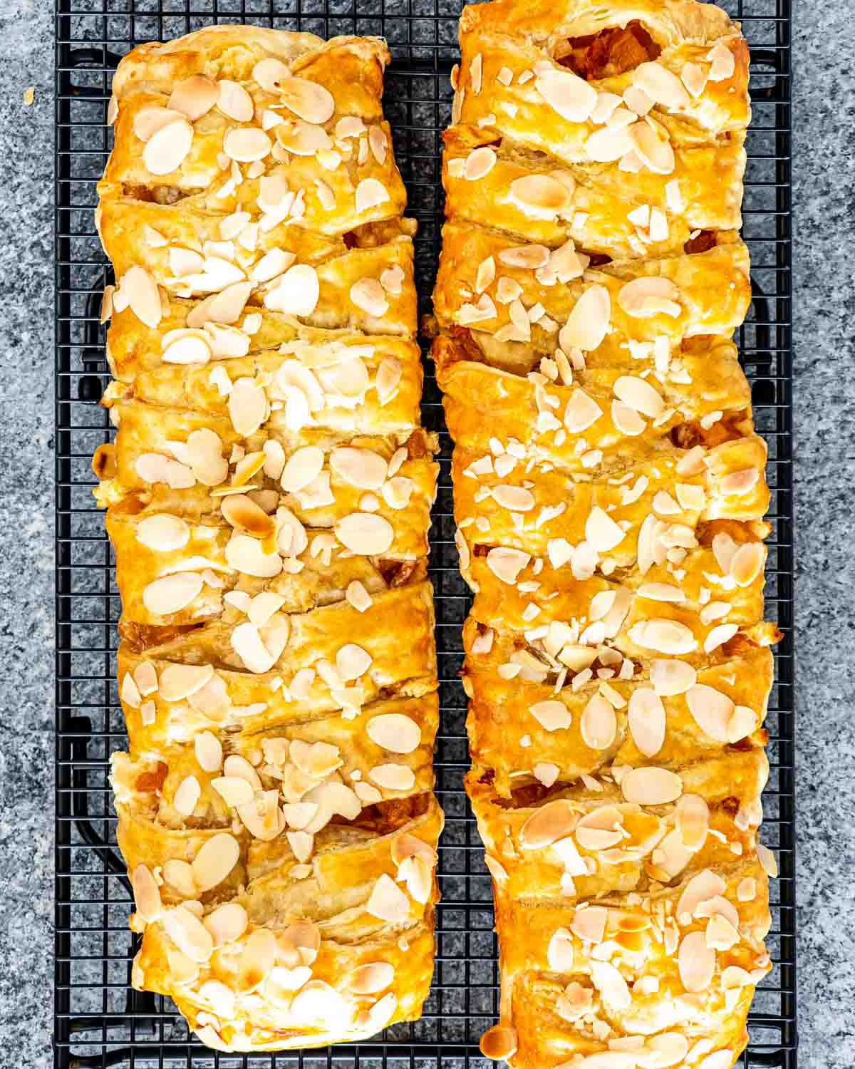 two peach strudels on a cooling rack.
