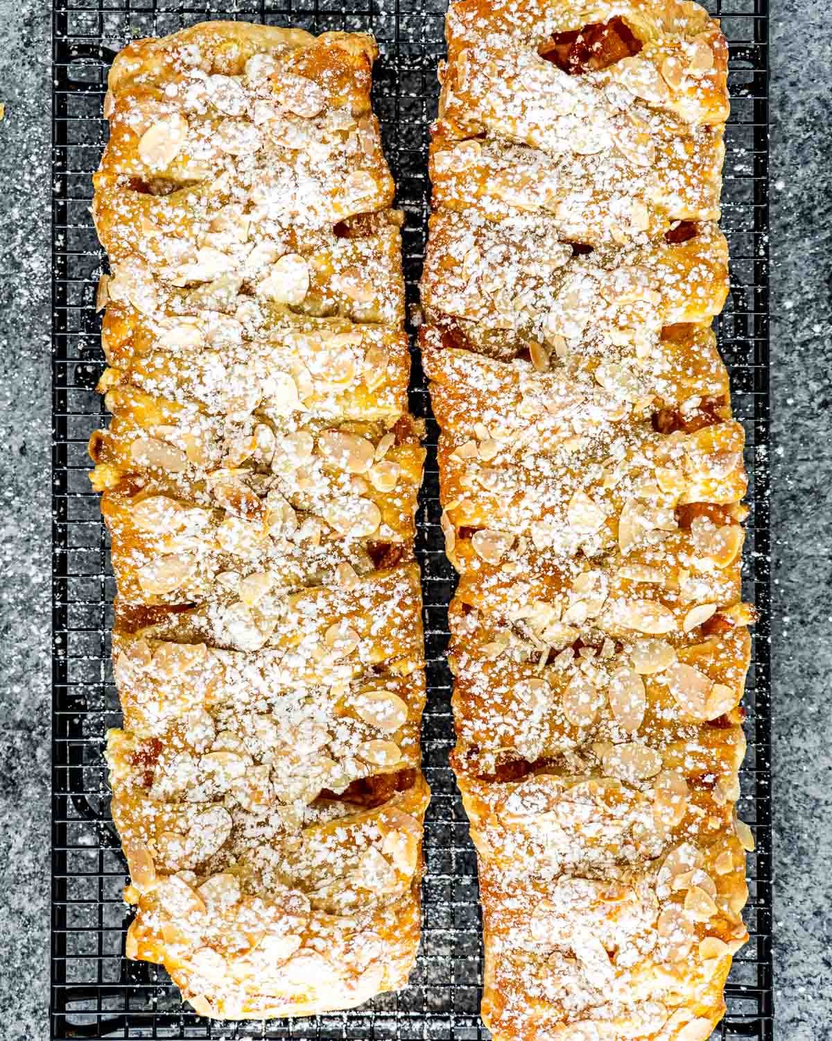two peach strudels on a cooling rack.