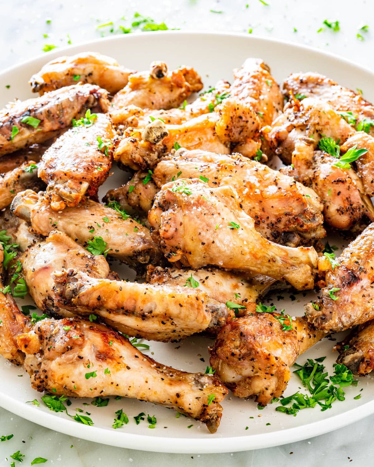 crispy salt and pepper wings on a white plate