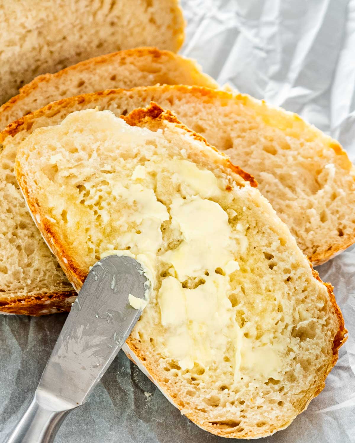 spreading butter on a slice of bread.