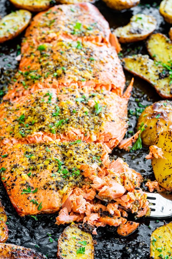 baked lemon pepper salmon with a piece being flaked by a fork