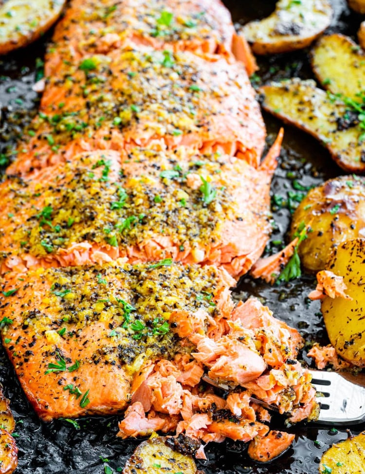 baked lemon pepper salmon with a piece being flaked by a fork