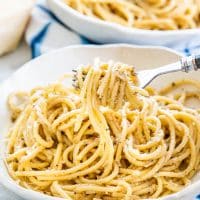 a fork taking a bite of cacio e pepe from a bowl