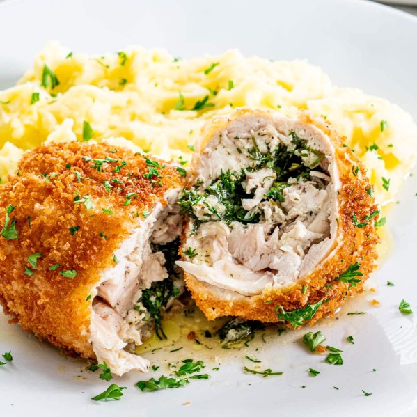 side view shot of chicken kiev on a plate with mashed potatoes