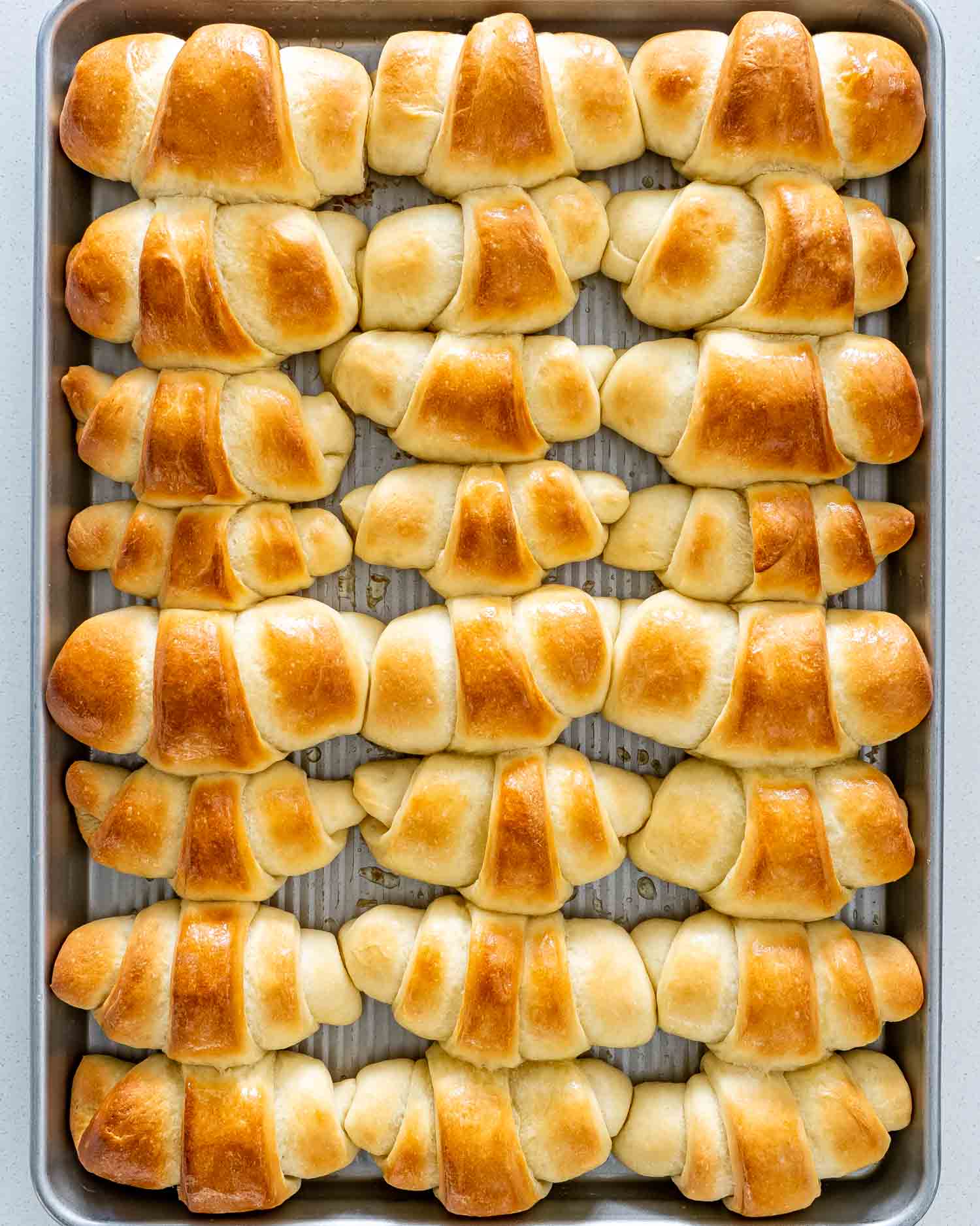 freshly baked crescent rolls on a baking sheet.