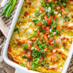 green chile chicken enchilada casserole in a white casserole dish fresh out of the oven.