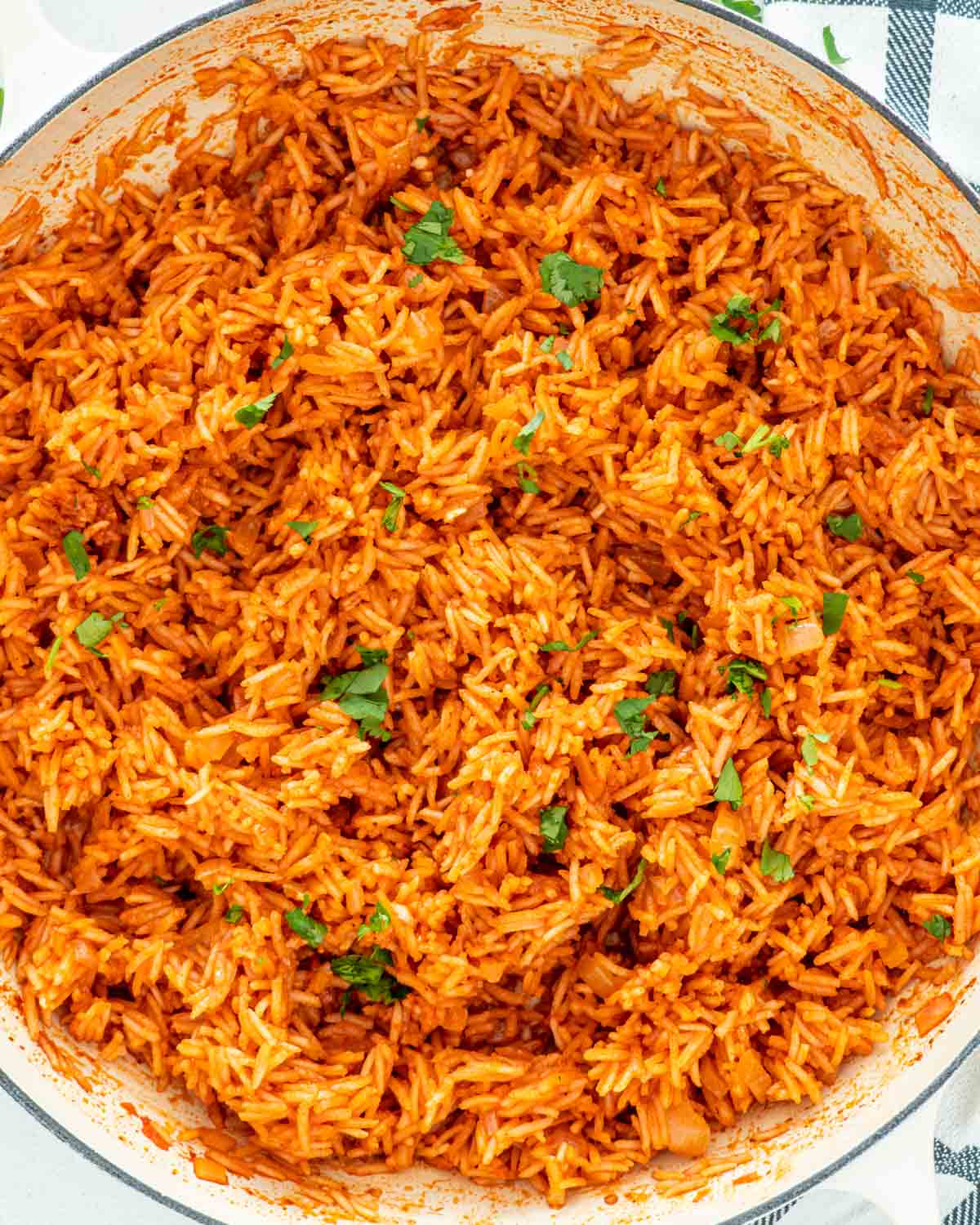 freshly made mexican rice in a skillet garnished with cilantro.