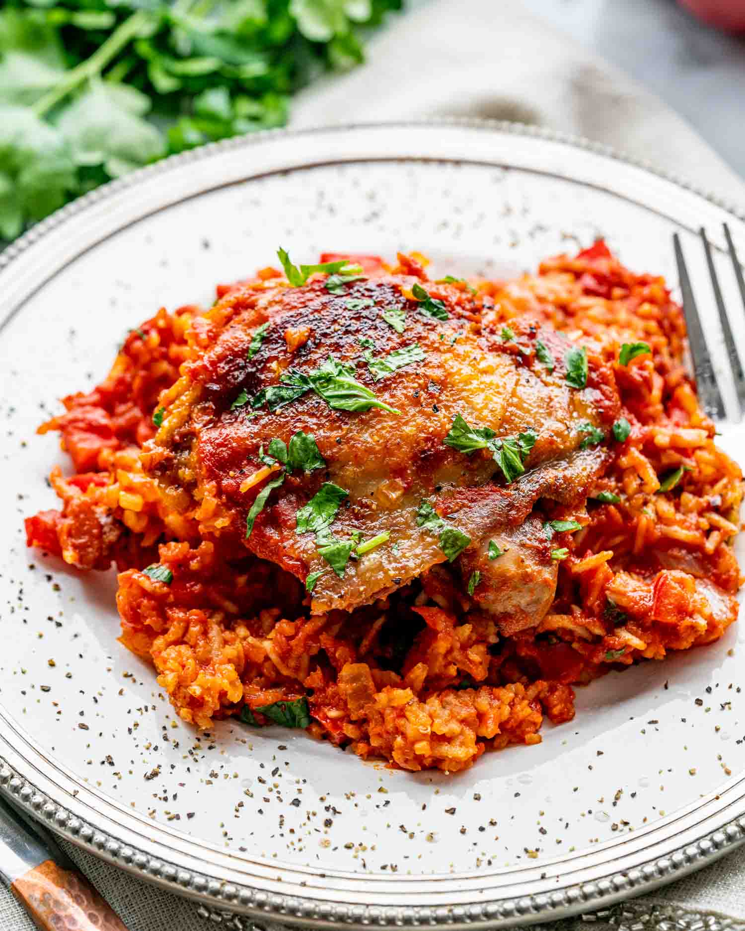 a serving of spanish chicken and rice on a white plate.