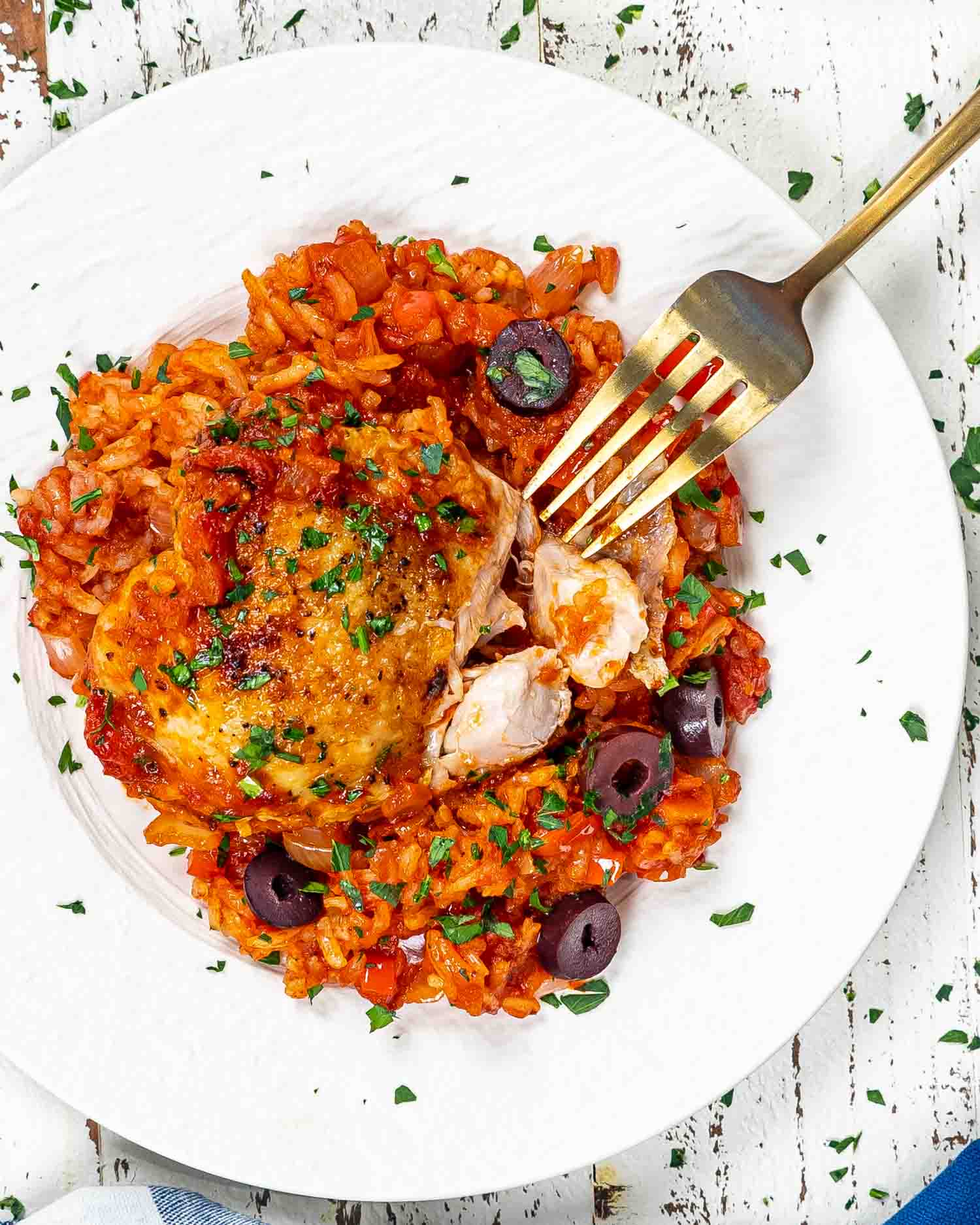 a serving of spanish chicken and rice on a white plate.