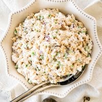 overhead shot of tuna macaroni salad in a decorative serving bowl with a serving spoon in it