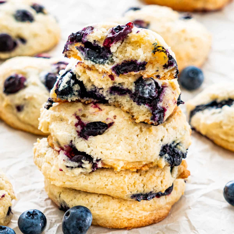 a stack of blueberry cheesecake cookies with the top one ripped in half