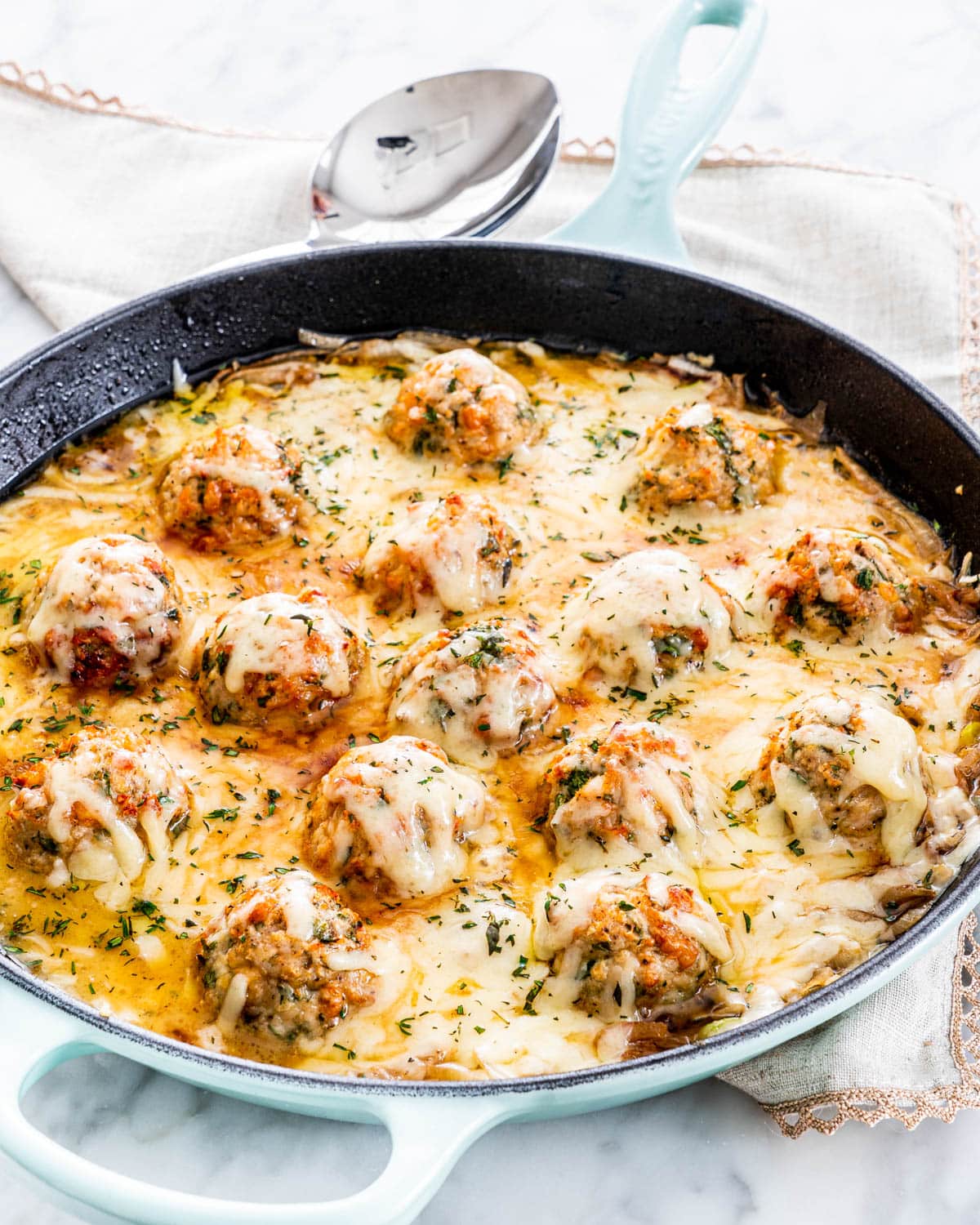a skillet loaded with French Onion Chicken Meatballs