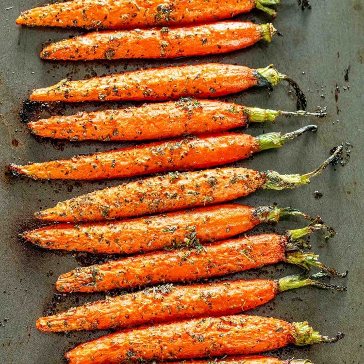 garlic herb roasted carrots on a baking sheet fresh out of the oven.