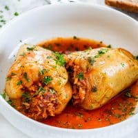 side view shot of two italian stuffed peppers in a bowl
