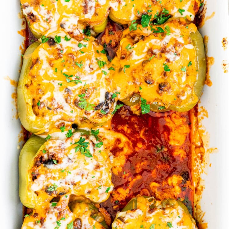 overhead shot of tex mex stuffed peppers in a baking dish with one missing