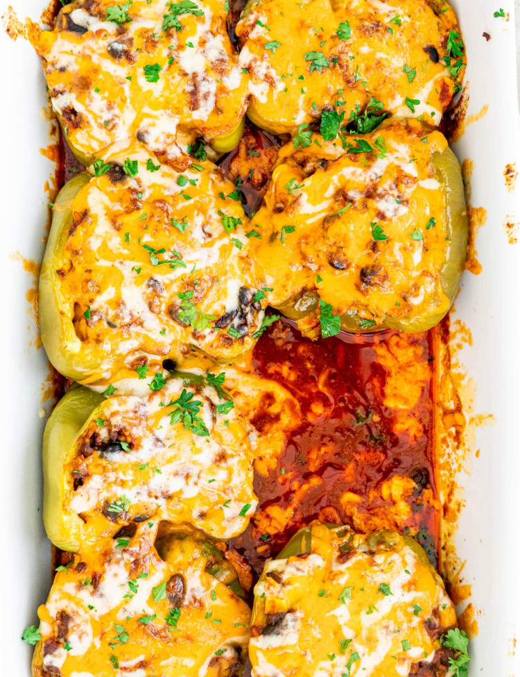 overhead shot of tex mex stuffed peppers in a baking dish with one missing
