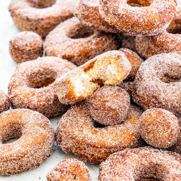 a bunch of apple cider donuts stacked on top of each other with a bite taken out of one