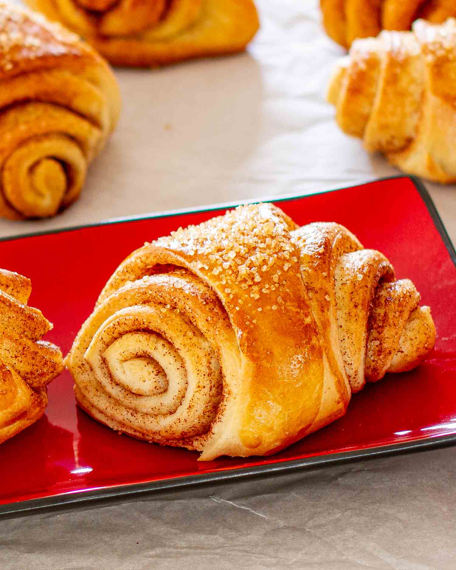 freshly baked finnish cardamom rolls on a red plate.